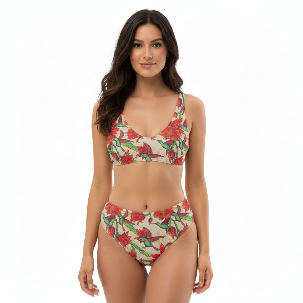 Woman wearing high-waisted bikini with colorful hummingbird and tropical flower print.