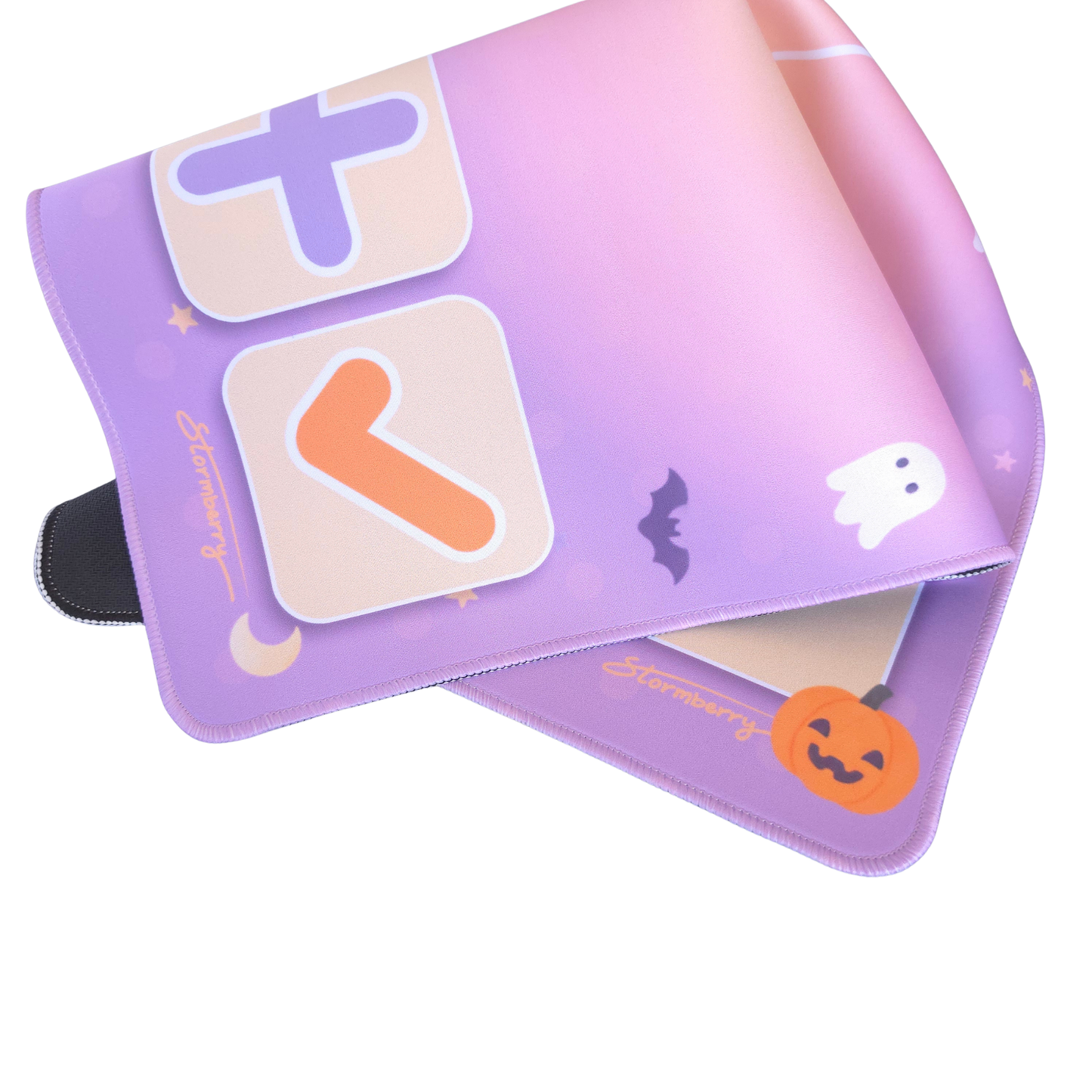 Pastel Halloween trading mat rolled to show the non slip black rubber backing