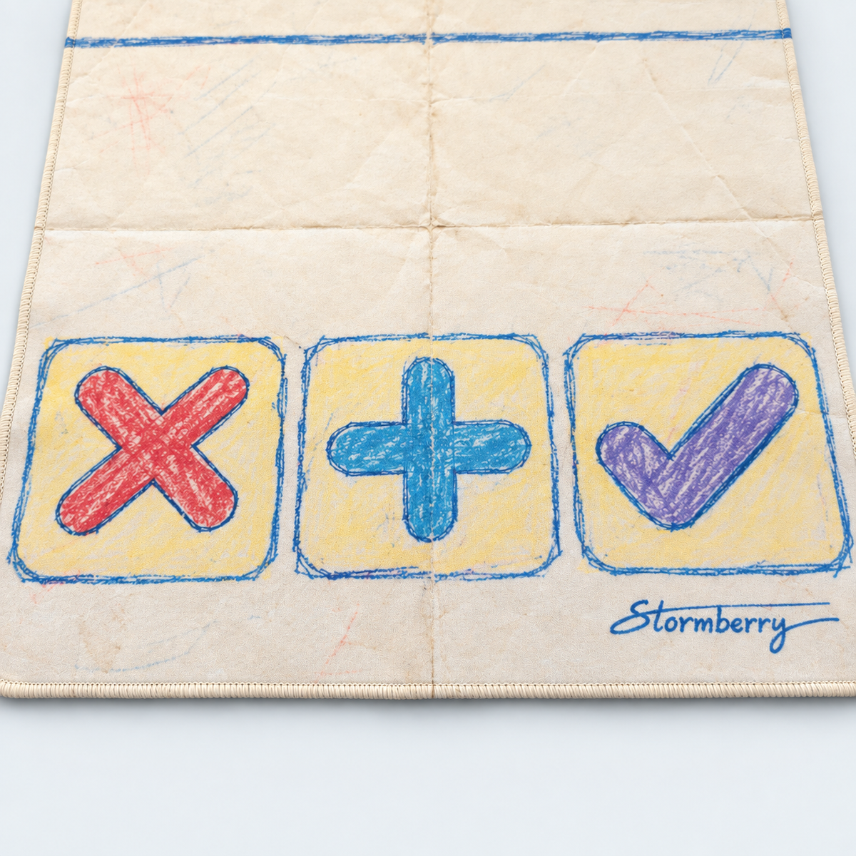 Detail of Paper Crayon's red X, blue plus and purple check on yellow panels, with cream stitching and the Stormberry signature.