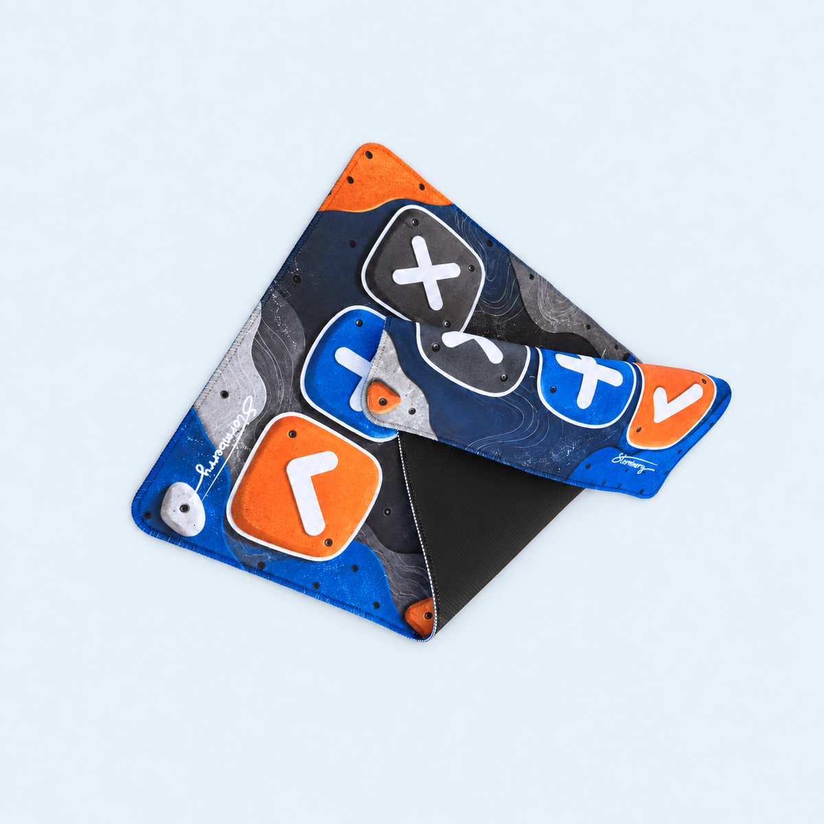 XL Boulder Field trading mat folded to reveal its black rubber backing.