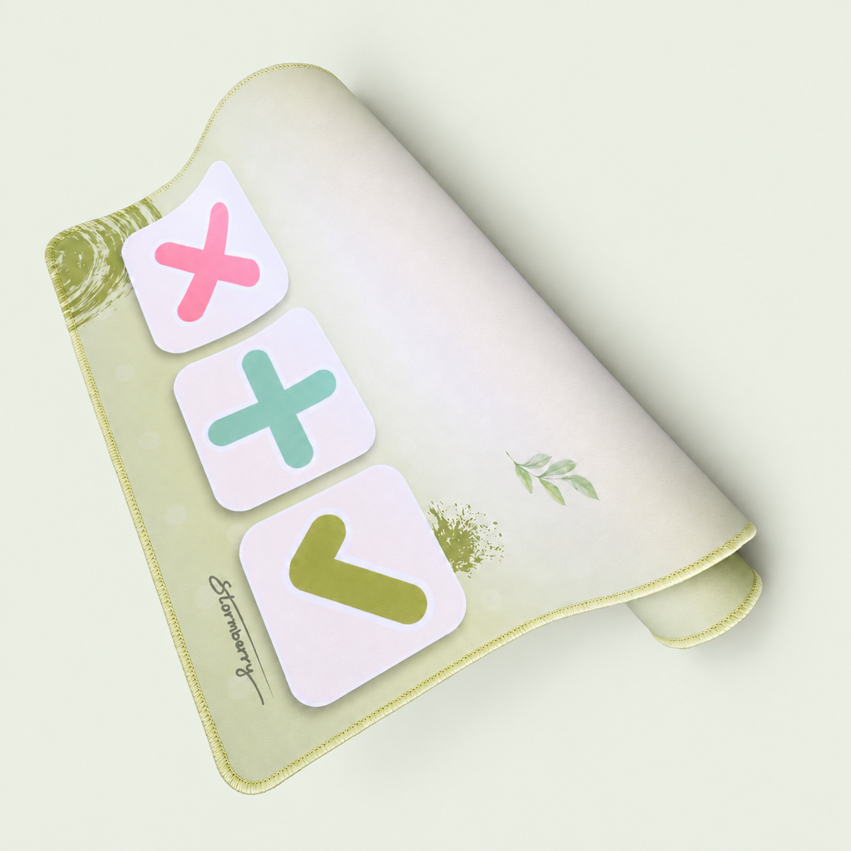 Partly folded Matcha Garden XL trading mat with botanical print, pastel trading symbols and stitched edge on a pale sage background.