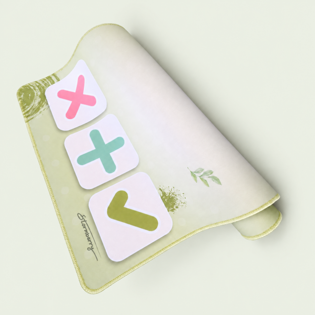 Partly folded Matcha Garden XL trading mat with botanical print, pastel trading symbols and stitched edge on a pale sage background.